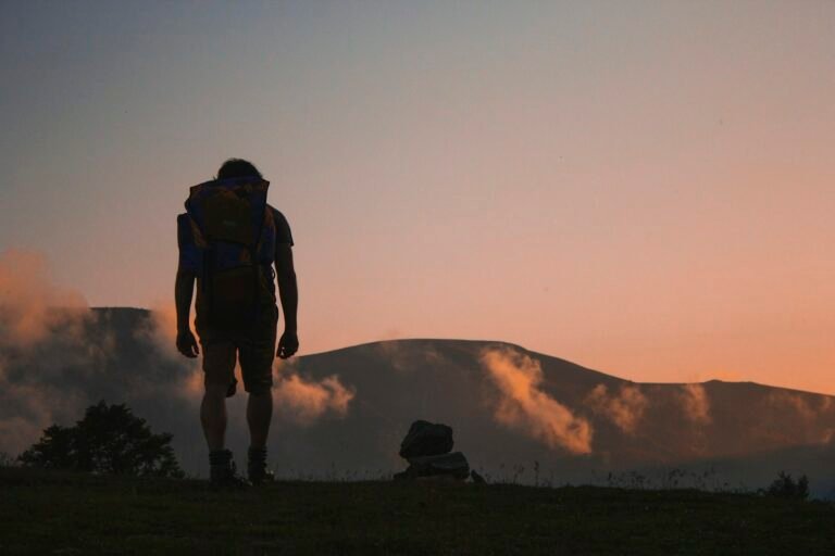 Backpacker on a mountain trail with a lightweight power station backpacking setup