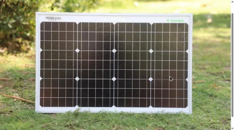 Portable monocrystalline solar panel set up on grass to charge a power station outdoors