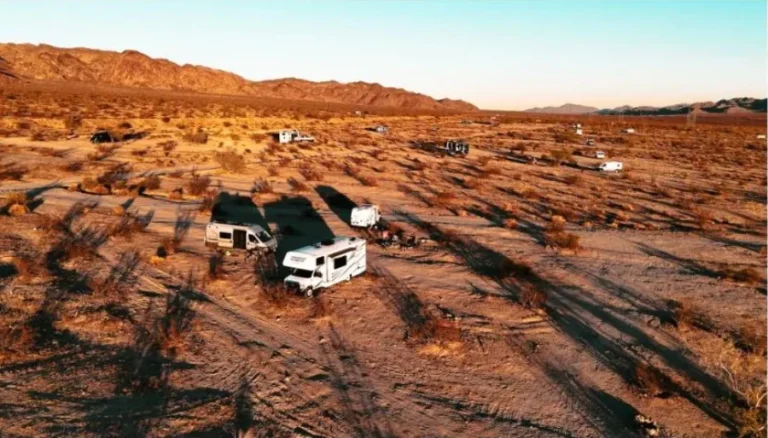 Aerial view of RVs boondocking in the desert at golden hour sunset
