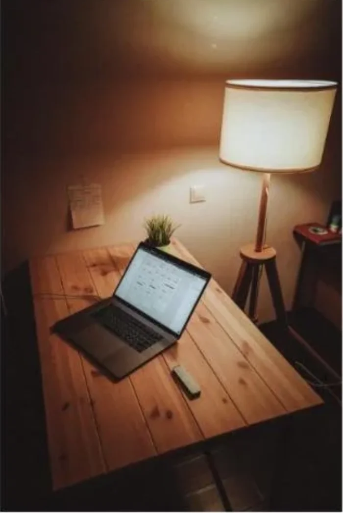 Warmly lit home office desk with a laptop and lamp, ready for backup power